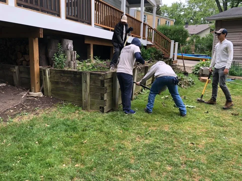 RG Hardscape crew building a timber retaining wall