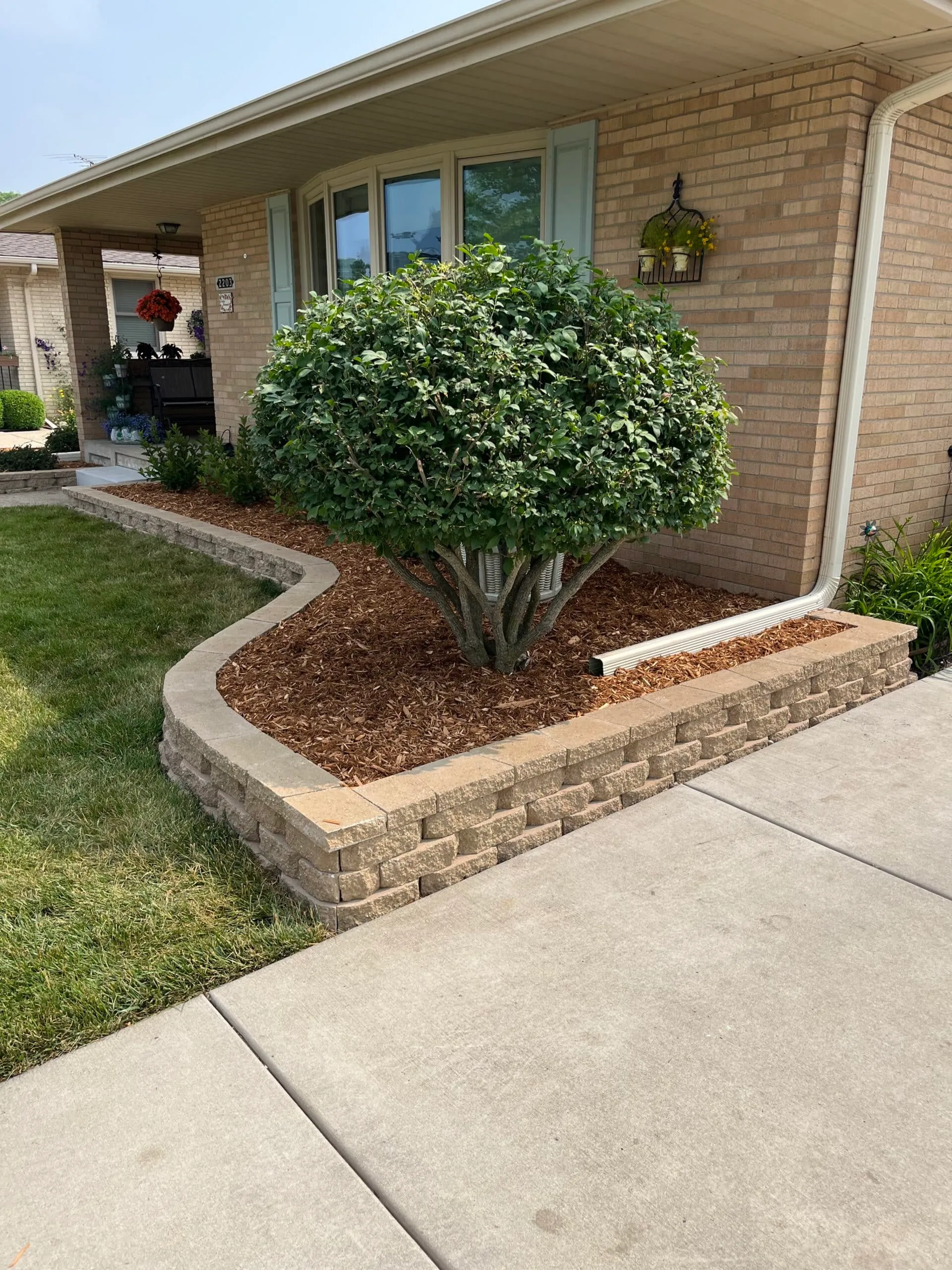 Manicured front-yard planting bed with brick border