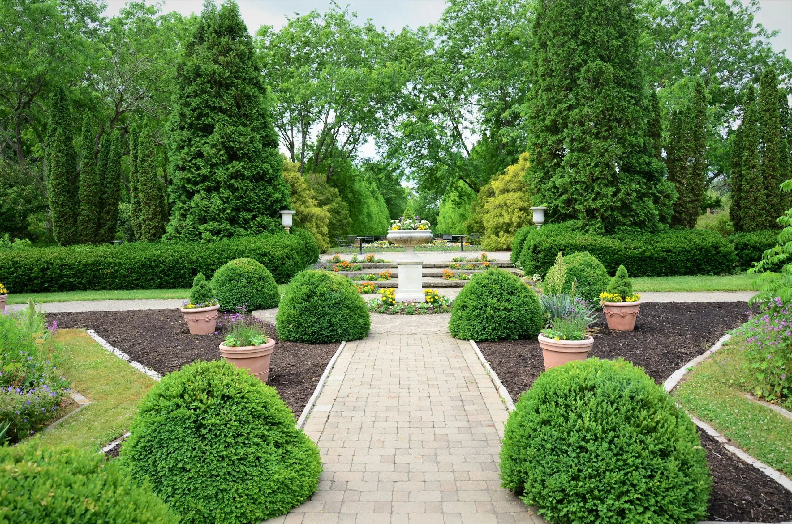 Formal garden with brick pathway and manicured hedges