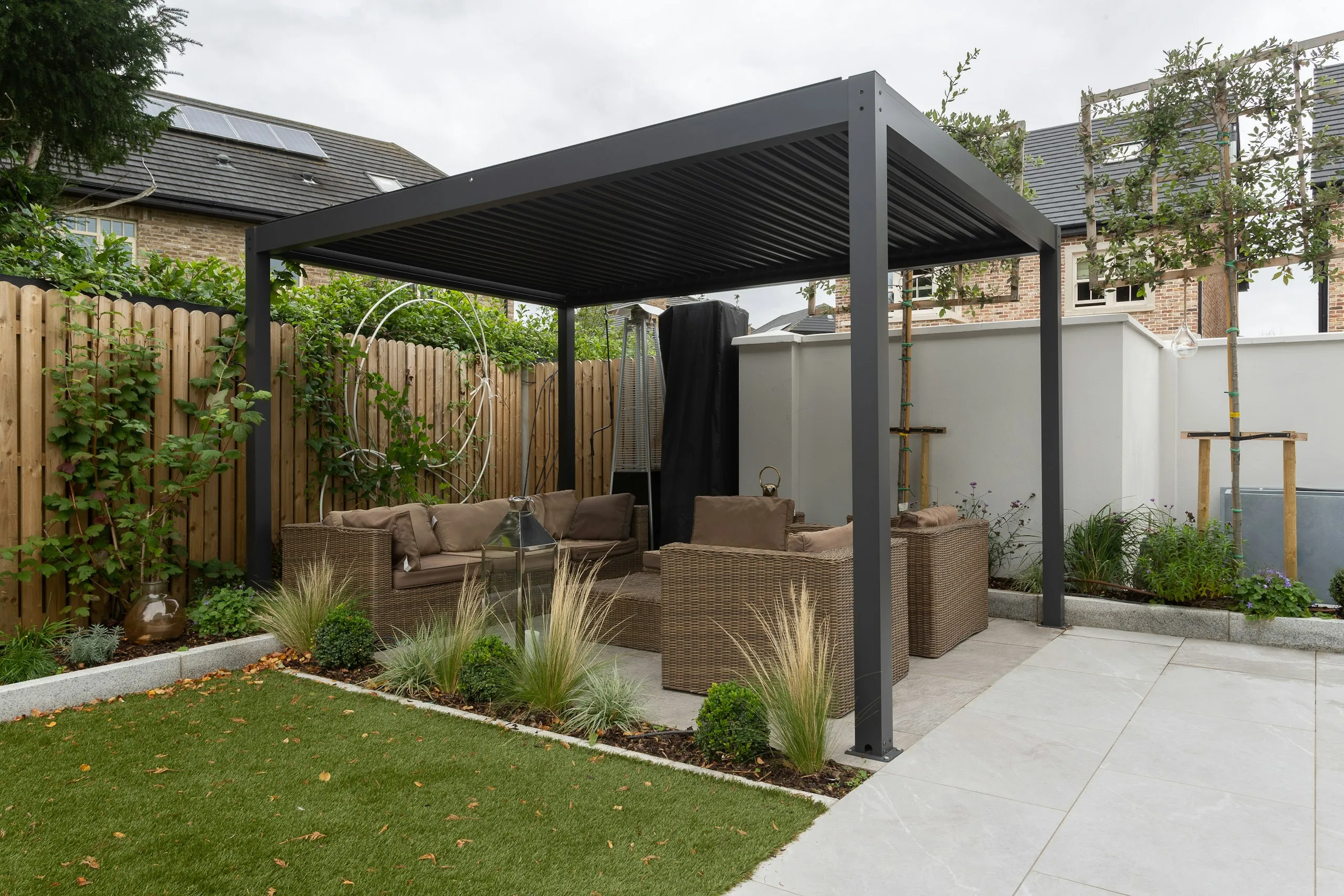 Modern pergola over a stone patio with outdoor lounge furniture